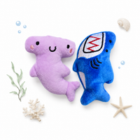 Purple shark and blue shark plush toys on a white background with sea-themed decorations.
